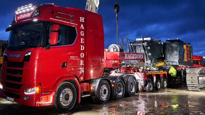 Schwertransport und Überführung eines Baggers in der Nacht